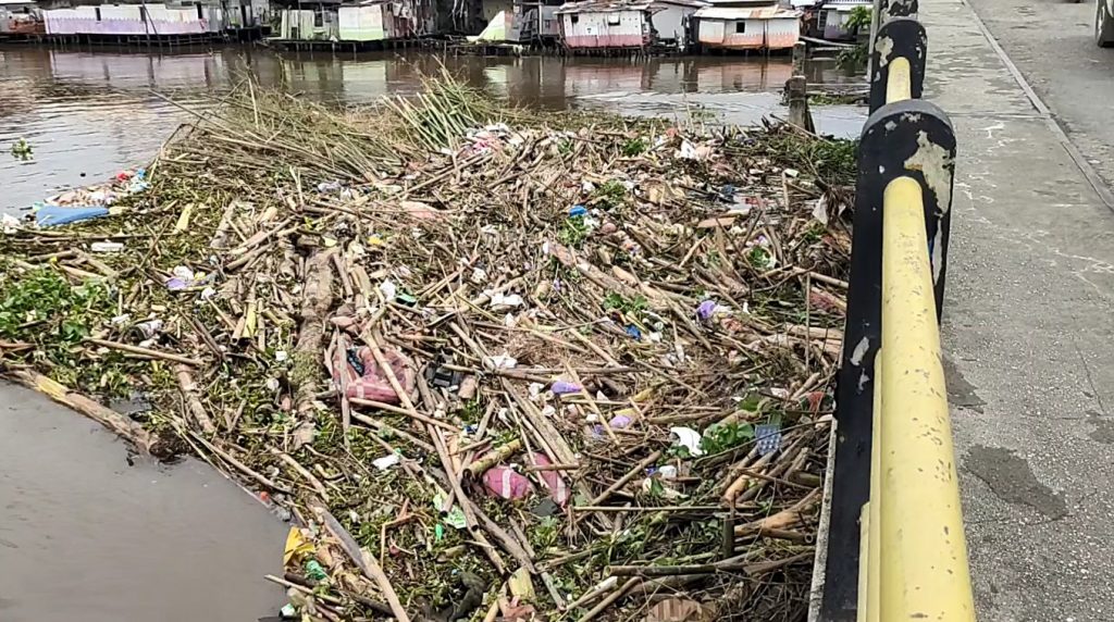 Tumpukan Sampah Dan Ranting Penuhi Alur Sungai Di Jembatan Pasar Lama