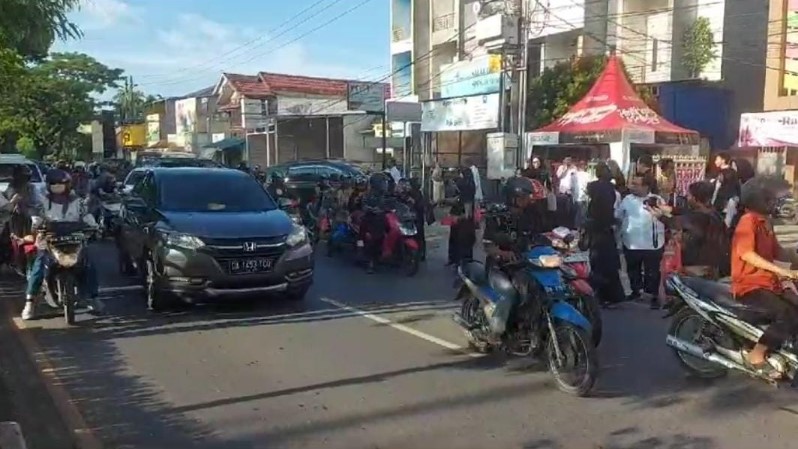 karyawan studio photo di kawasan Kayu Tangi membagikan takjil di depan studio photo