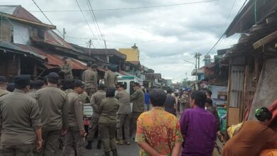 Sejumlah personel Satpol PP Kota Banjarmasin terlihat melakukan pemotongan pada atap pedagang Pasar Lama Laut