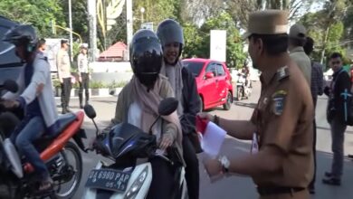 Pj Bupati Tala saat membagikan bendera merah putih