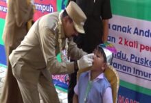 Pj Bupati Tanah Laut Syamsir Rahman, secara simbolis memberikan imunisasi polio kepada salah seorang anak