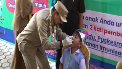 Pj Bupati Tanah Laut Syamsir Rahman, secara simbolis memberikan imunisasi polio kepada salah seorang anak