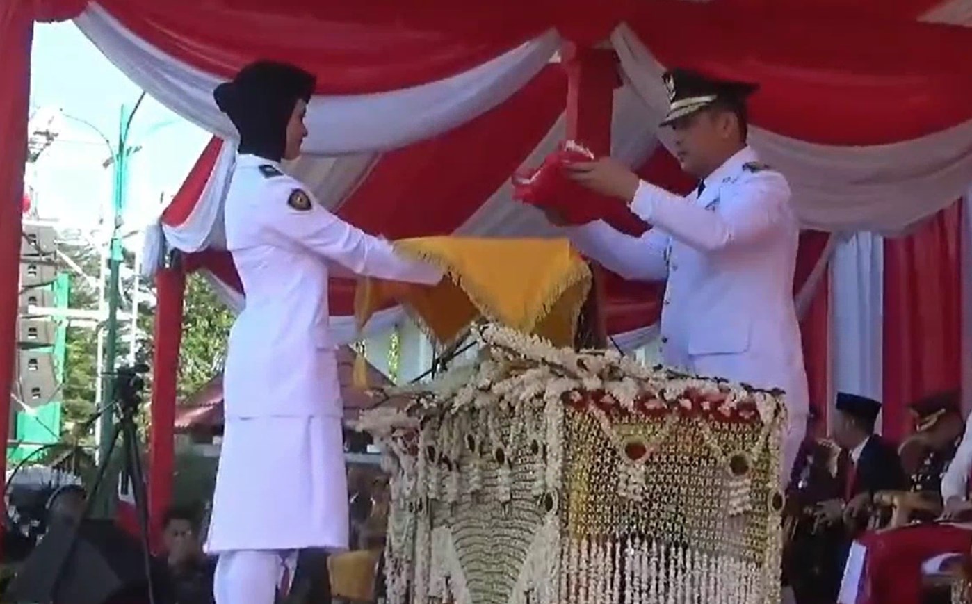 Syamsir Rahman, PJ Bupati Tanah Laut saat menyerahkan bendera merah putih